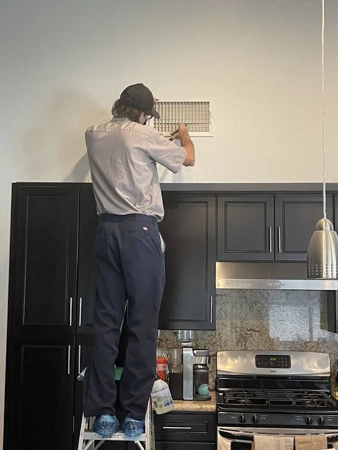 Technician inspecting an air vent during HVAC service in Hawthorn Woods
